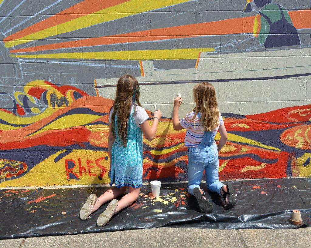 Young artists from Rock Hall Elementary School paint a mural outside Bayside Market
